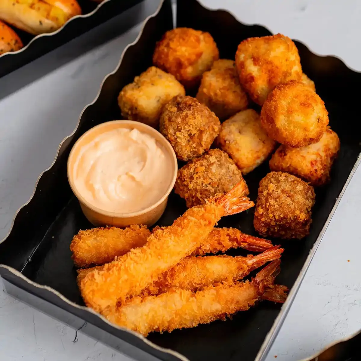 Croquetas y langostinos rebozados con salsa en caja de catering, María Lluch Catering en Madrid