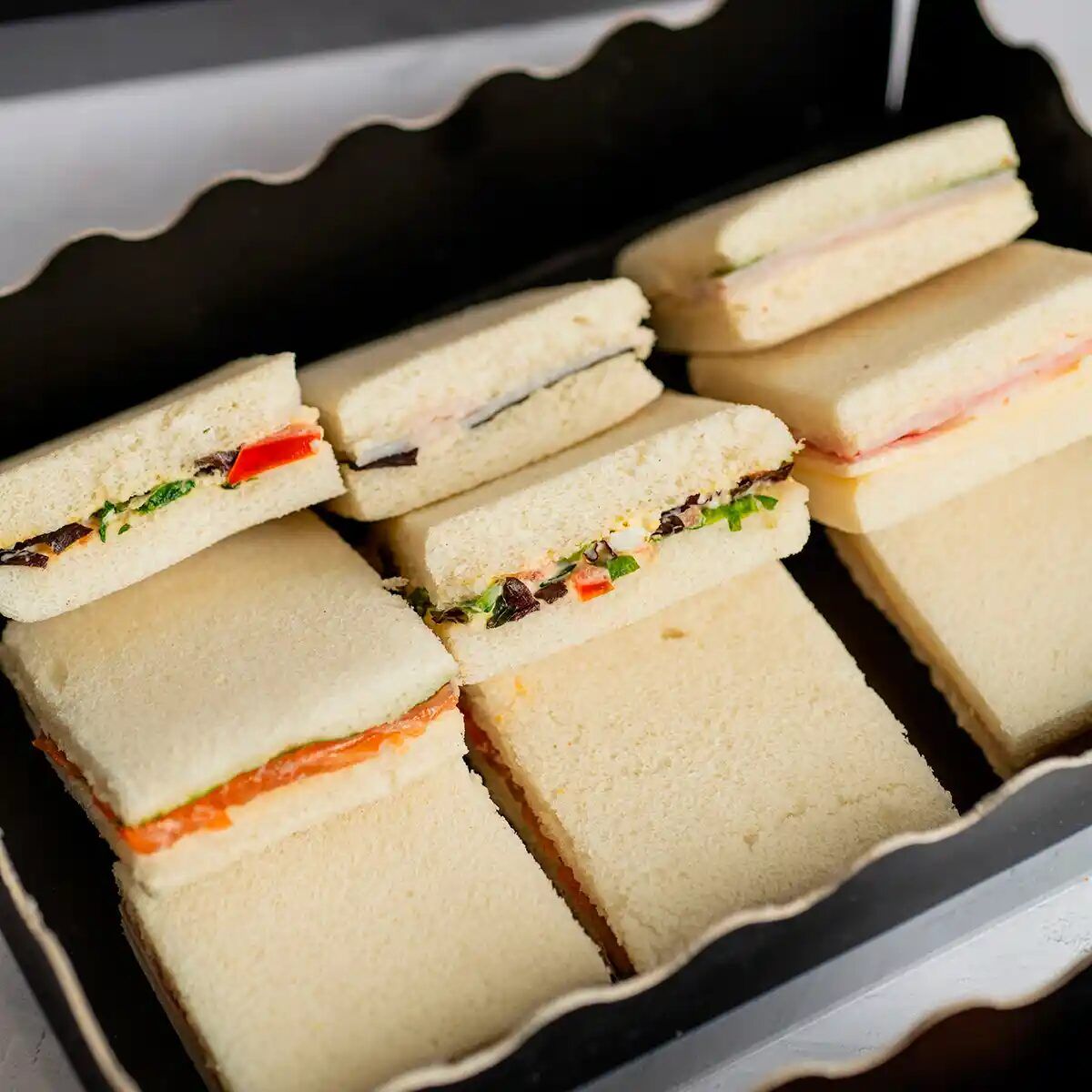 Box of assorted mini sandwiches for a business breakfast or meeting, María Lluch catering in Madrid