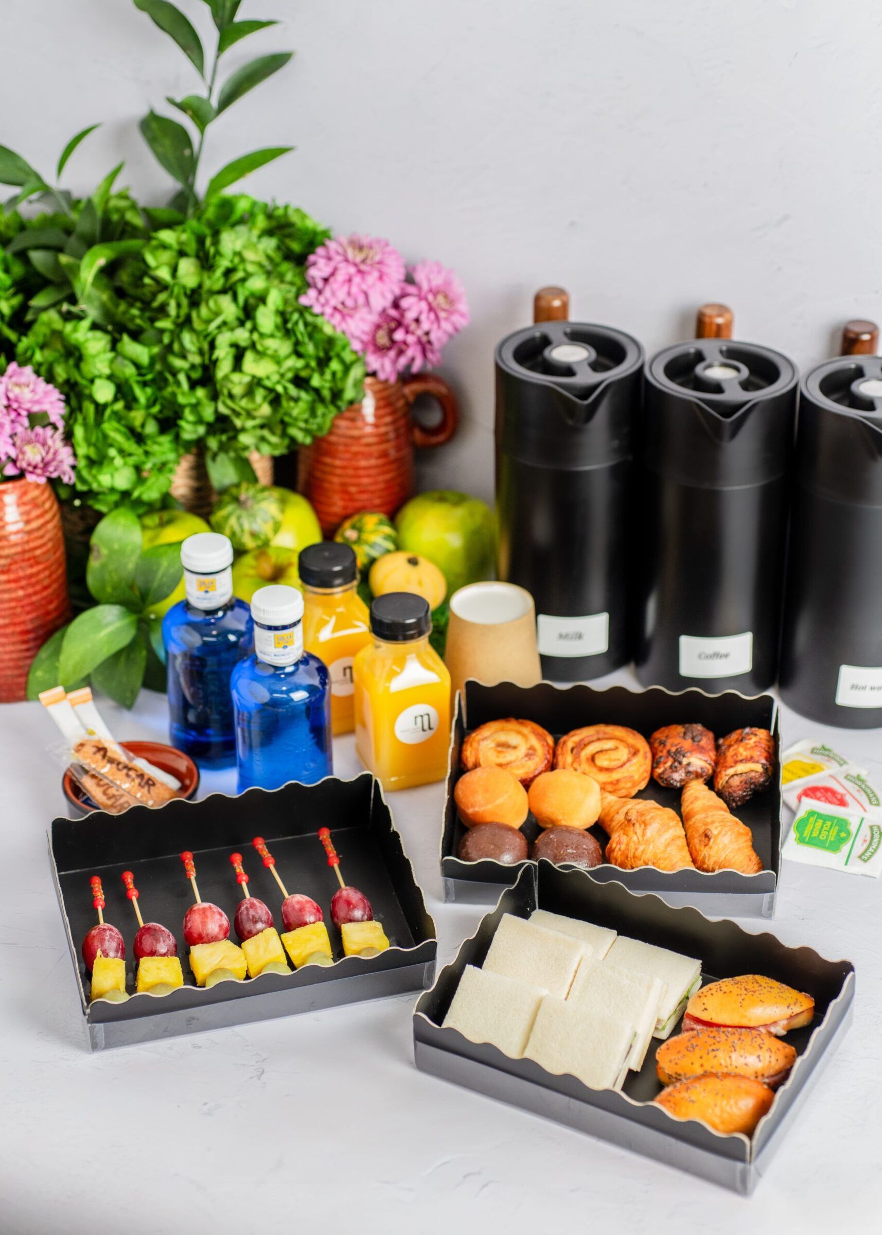 Office coffee break service with pastries, fruit skewers, juices and flasks of coffee, María Lluch Catering in Madrid