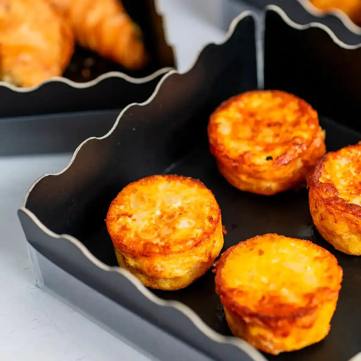 Mini tortillas de patata doradas en caja de catering, María Lluch Catering en Madrid