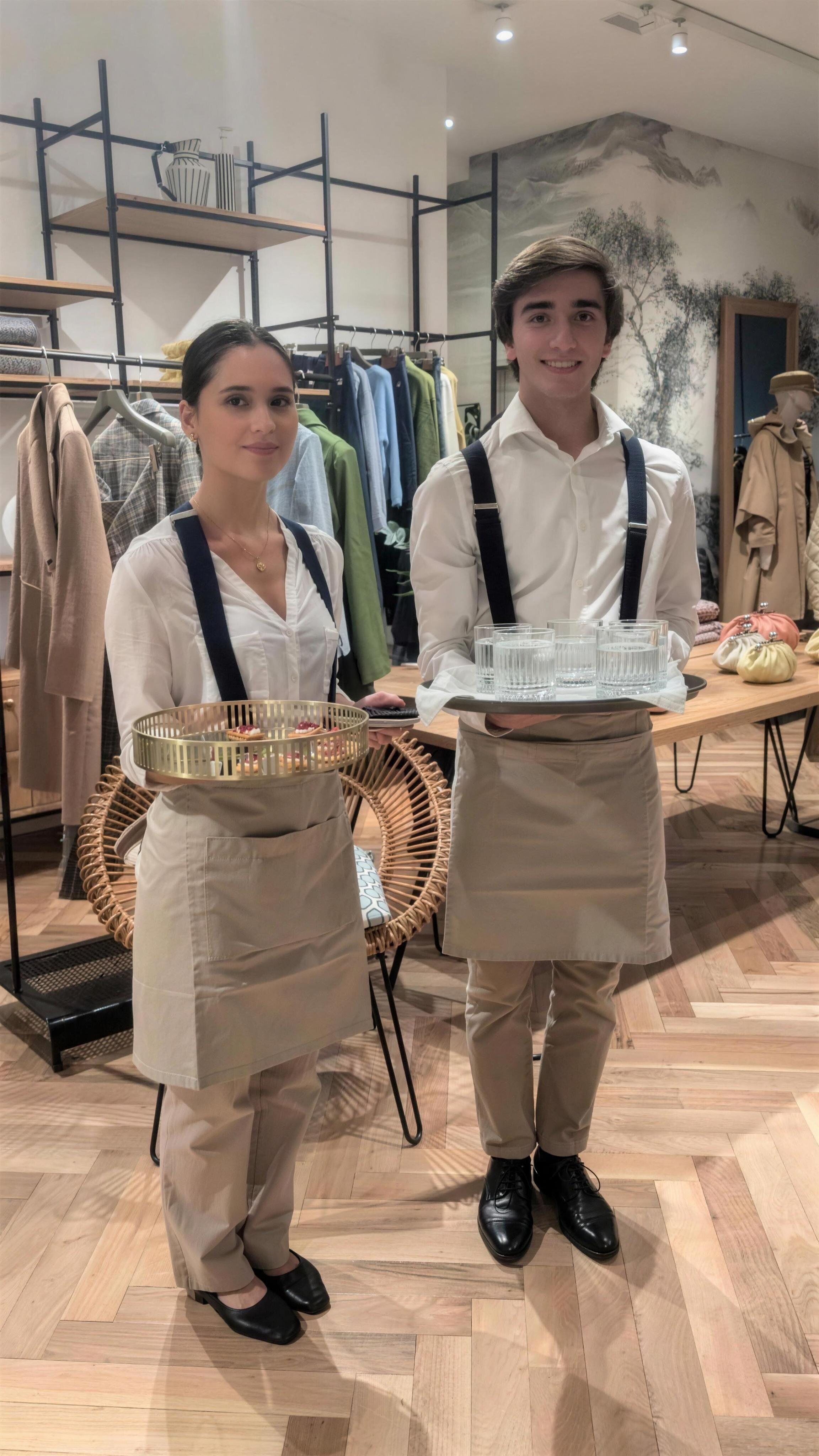 Camarera y camarero de María Lluch Catering con aperitivos y agua sirviendo en un evento