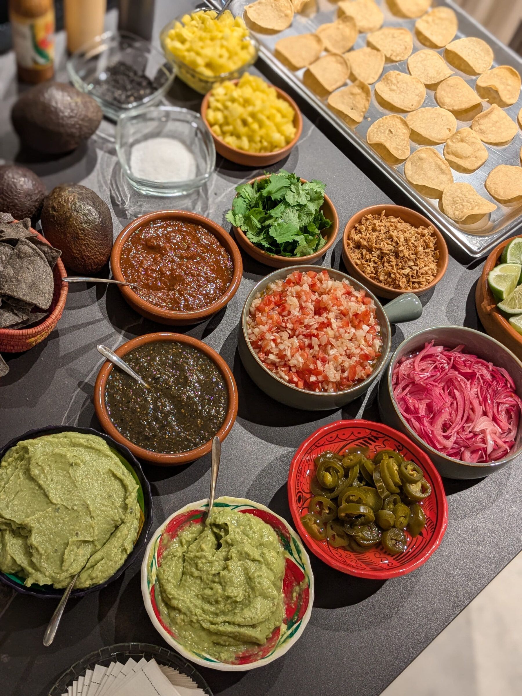 Mexican live cooking table with guacamole, salsas, pico de gallo, jalapeños and tostadas, María Lluch catering in Madrid