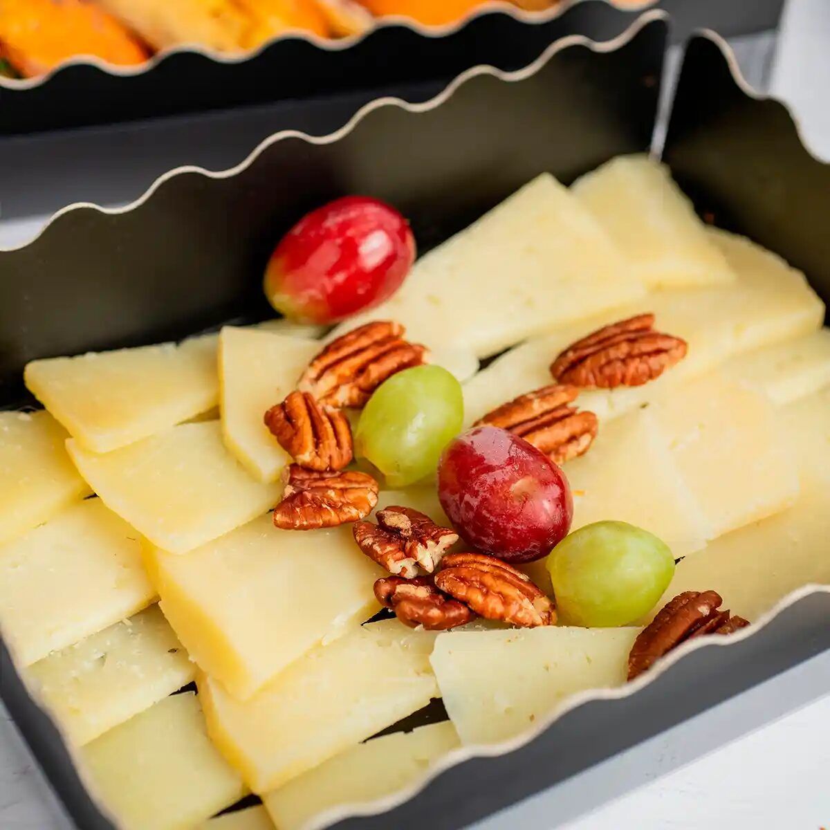 Cured cheese board with pecan nuts and grapes, María Lluch catering in Madrid